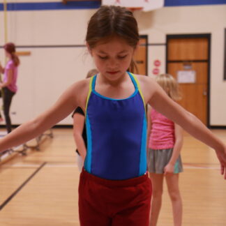 Girl balances in gymnastics class