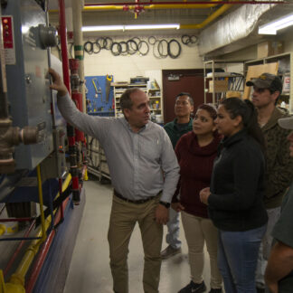 Instructor explains boiler mechanisms to a group of adult students