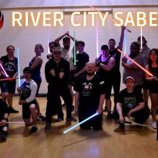 Large group of adults pose with their lightsabers.