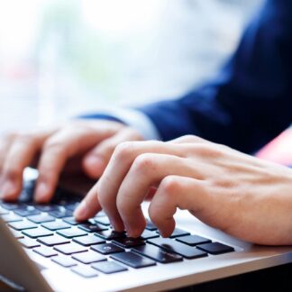 Hands typing on a laptop.