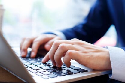 Hands typing on a laptop.