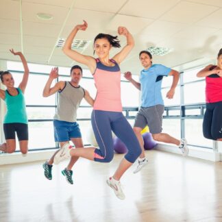 Adults in workout wear each jump enthusiastically while working out.