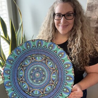 Course instructor holds an example of her mandala design artwork.