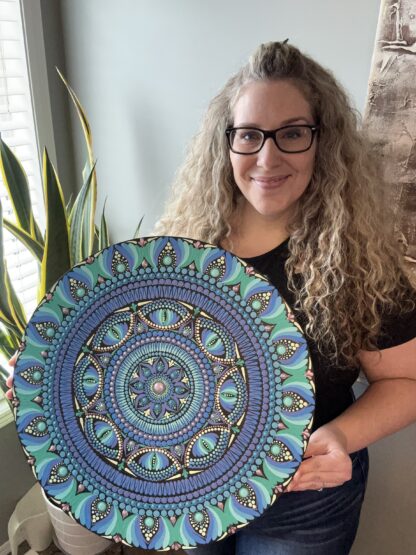 Course instructor holds an example of her mandala design artwork.