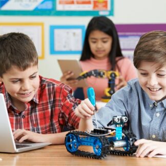 Children laugh as they work on a Lego robot