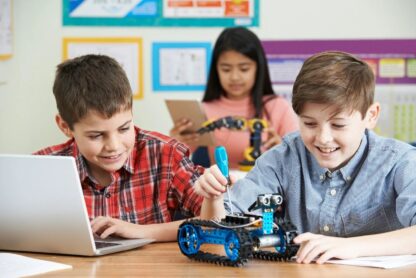 Children laugh as they work on a Lego robot