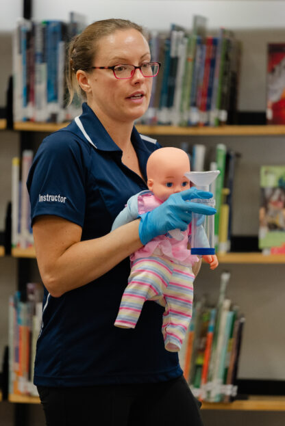 instructor holds a baby doll