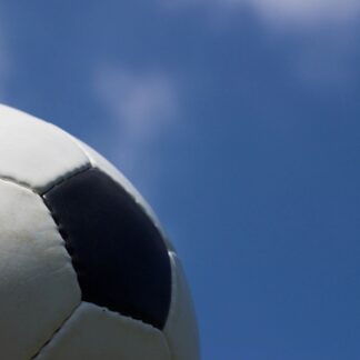 Part of a soccer ball against a blue sky