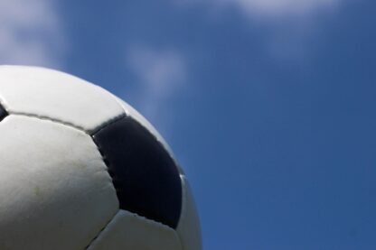 Part of a soccer ball against a blue sky