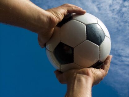 Hands holding a soccer ball