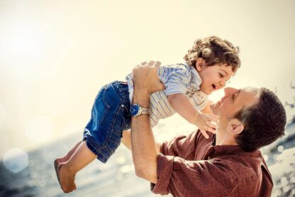 Father holds child in the air