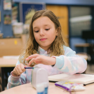 girl sharpens pencil