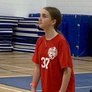 girl in red shirt waits for volleyball
